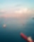 An aerial view overlooking a busy maritime scene with numerous cargo ships and tankers scattered across a wide expanse of calm blue water.