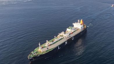 Aerial view of an LNG (liquefied natural gas) tanker sailing on open water, with “LNG” marked prominently on the ship’s side.