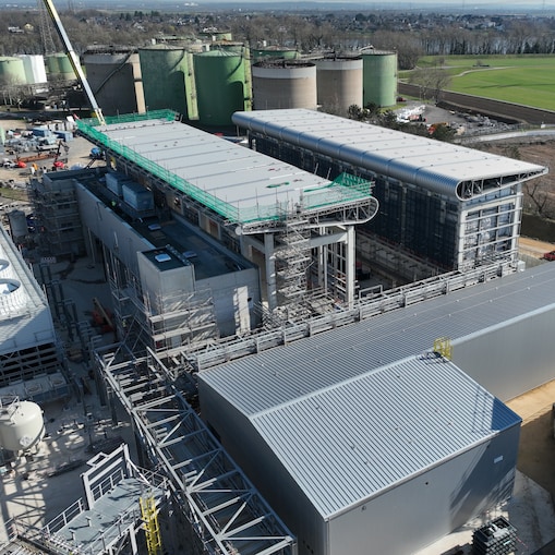 Aerial view of a large hydrogen production facility surrounded by storage tanks and industrial buildings.
