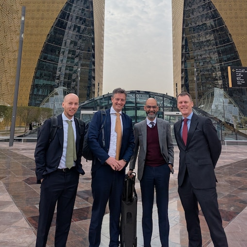 A picture of Ross Brown and his colleagues outside a modern structure.