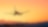 Silhouette of an airplane flying above clouds with a vibrant sunset sky in the background.