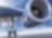 Close-up view from beneath a commercial airplane showing the aircraft's landing gear and jet engine against a bright blue sky.