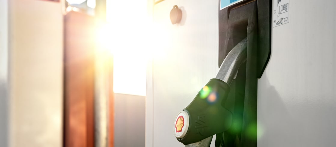 A close-up view of a fuel dispenser with a nozzle labelled "Shell Renewable Diesel" under bright sunlight