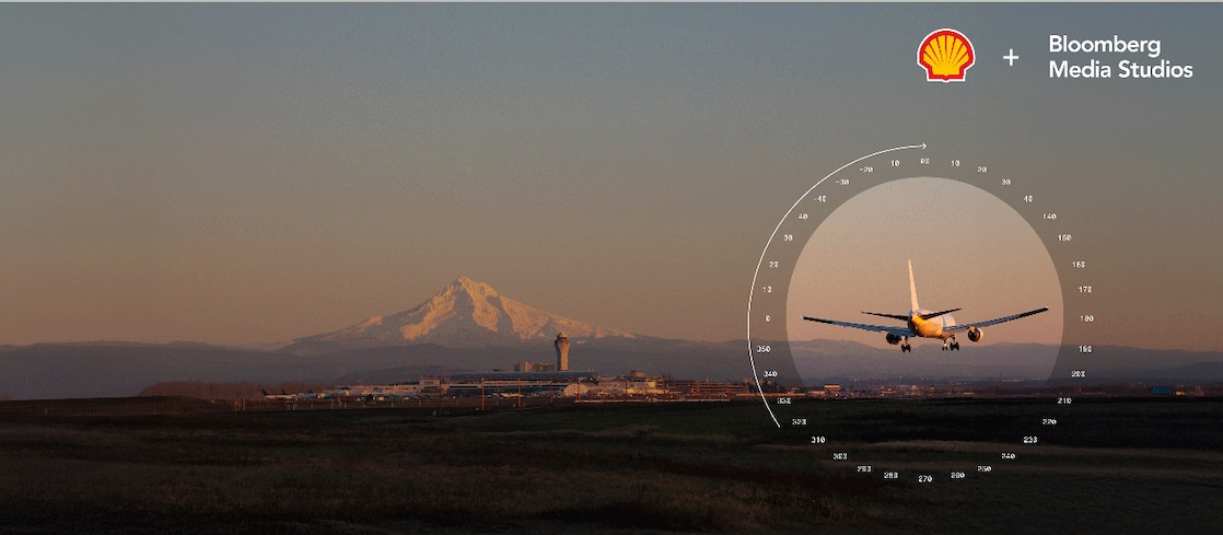 Passenger aircraft approaching a runway, with a mountain and airport infrastructure in the background.