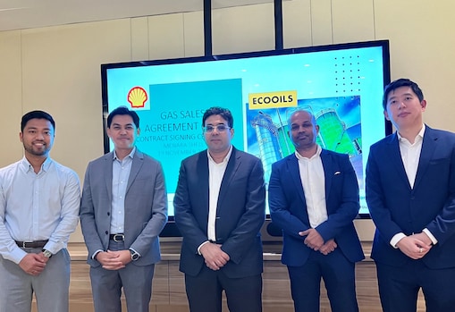 Rida stands with a group of professionals in a meeting room during a partnership or agreement event, facing forward.