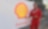 A Shell worker in a red coverall uniform gives a thumbs-up in front of a banner with the Shell logo and the word “Convent.”