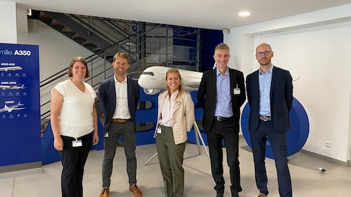 Marieke, pictured on the left, standing with colleagues and Airbus representatives at the Airbus A350 Final Assembly Line in Toulouse, France.