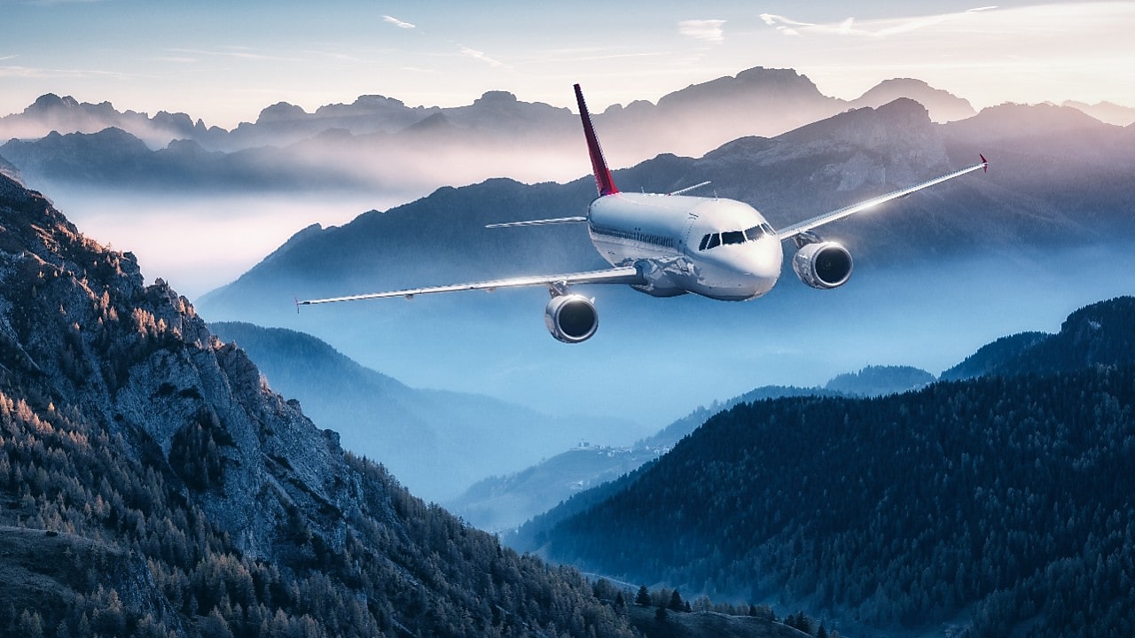 airplane flying above mountains