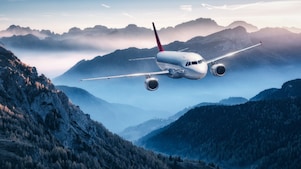 airplane flying above mountains