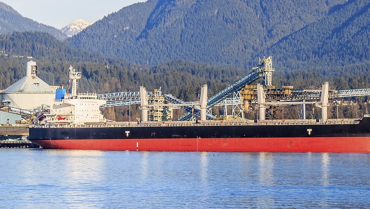 Boat docked next to a gas treatment plant and sulphur mounds