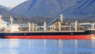 Boat docked next to a gas treatment plant and sulphur mounds