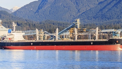 Boat docked next to a gas treatment plant and sulphur mounds