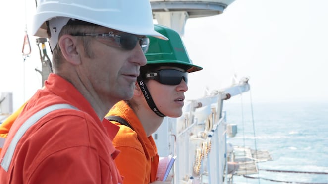 man and woman watching from ship
