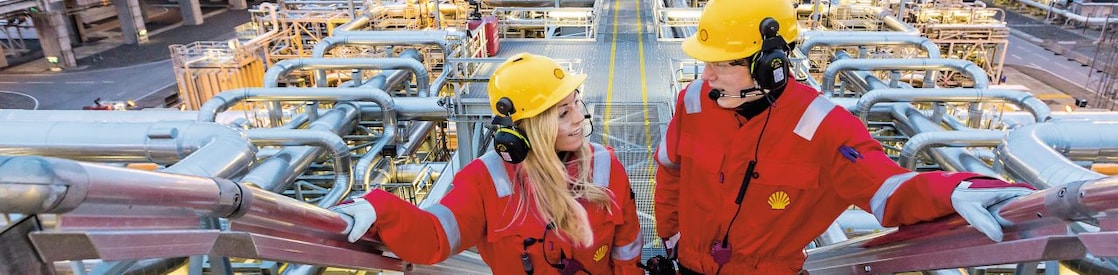 Two shell employees talking at work site