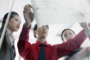 man showing bluprint to colleagues