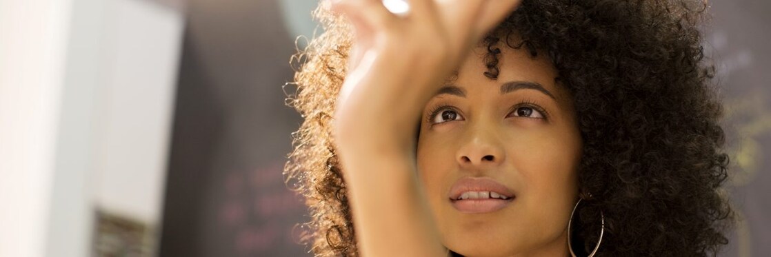 Businesswoman examining crystal ball in office