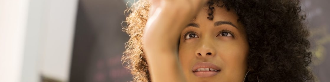 Businesswoman examining crystal ball in office