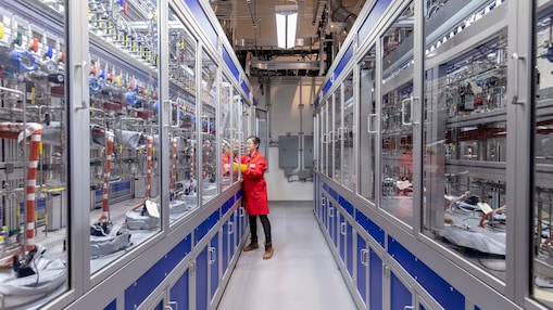 woman in red safety clothing performing laboratory work