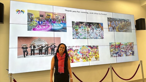Smiling woman standing in front of a large screen