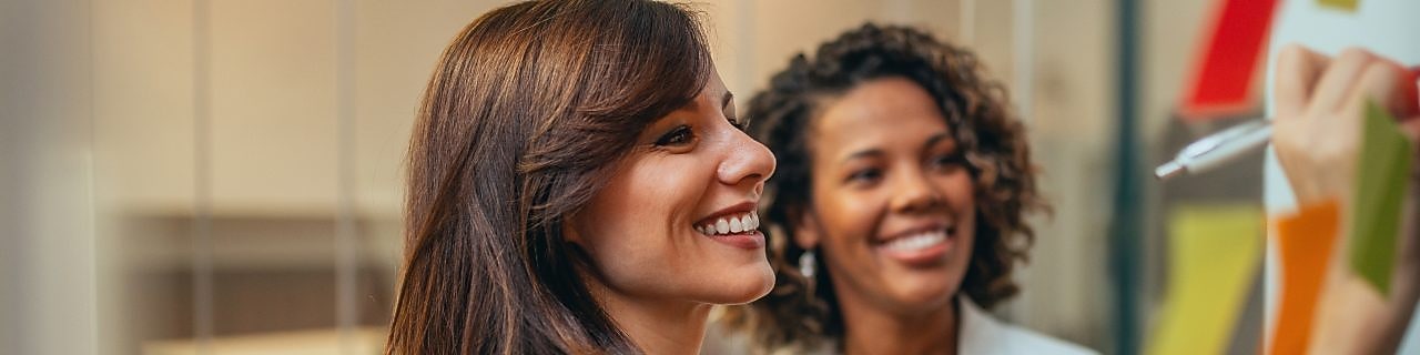Woman writing on board and smiling