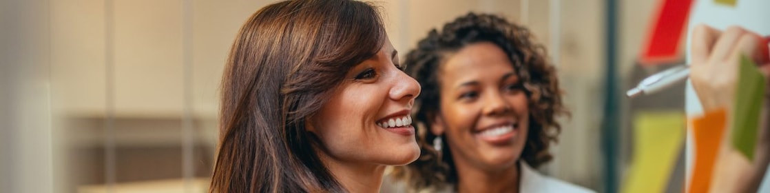 Woman writing on board and smiling
