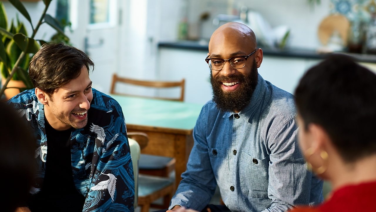 group of people talking and laughing in an office