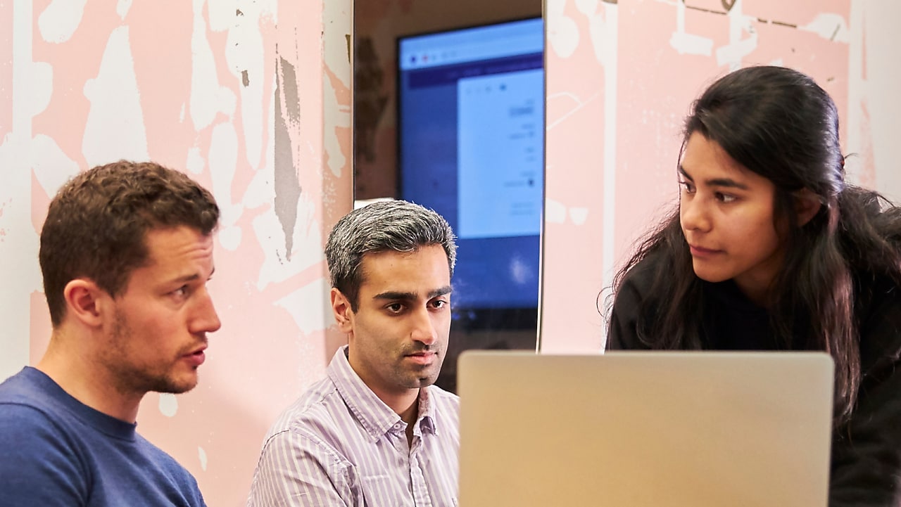 Three employees are having a discussion