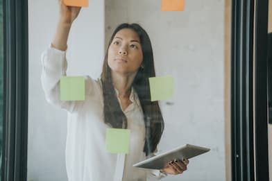 woman writing on sticky notes