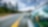 a wide expanse of empty road with a glimpse of a person driving in a car on the right