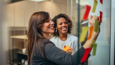 Woman writing on board and smiling