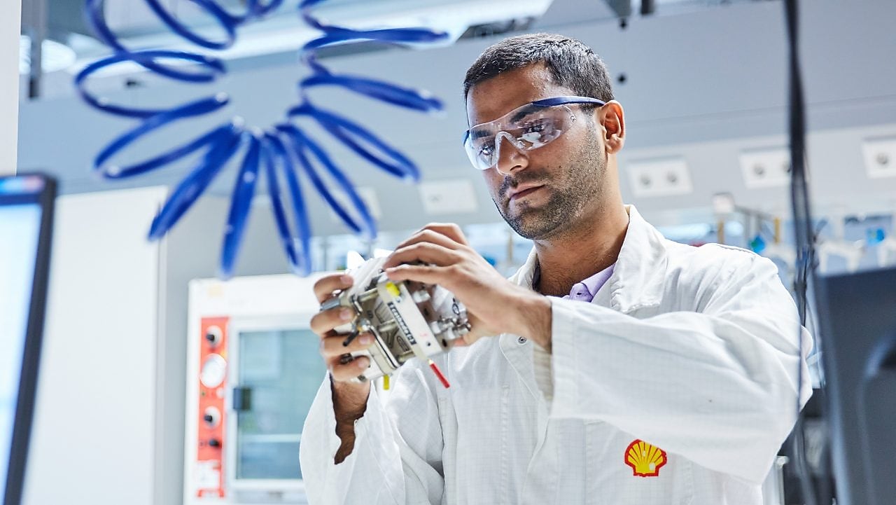 A Shell employee in protective clothing working in a lab