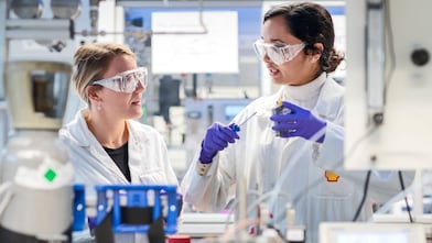 2 Shell employees in protective clothing working in a lab