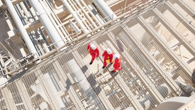 3 Shell employees in full PPE walking on a platform