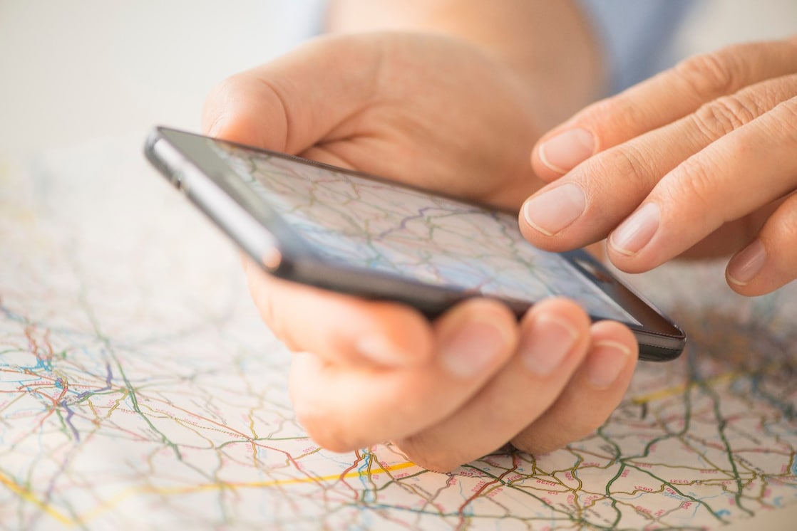 Close-up of hand using smartphone over map