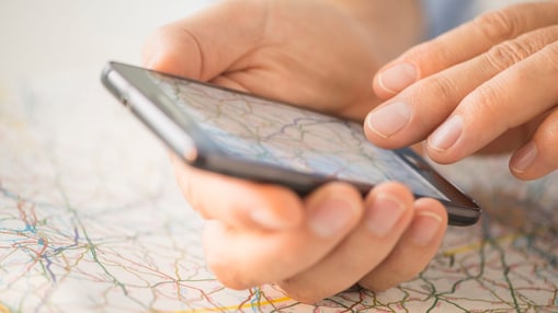 Close-up of hand using smartphone over map