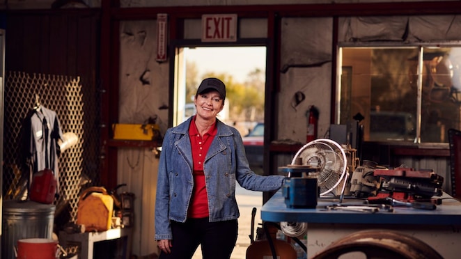 A lady truck driver smiling in a workshop
