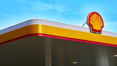 Shell service station canopy with the Shell logo against a blue sky.