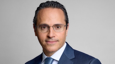 Formal headshot-style image of Wael Sawan with a neutral background.