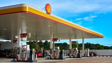 Shell service station with multiple fuel pumps and customers.