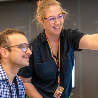 Emma Purton points towards a computer screen displaying project data in Shell's Perth office.