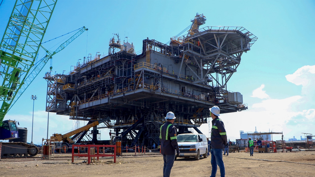 The Manatee topsides structure stands in a fabrication yard, with workers, vehicles and lifting equipment visible nearby.​