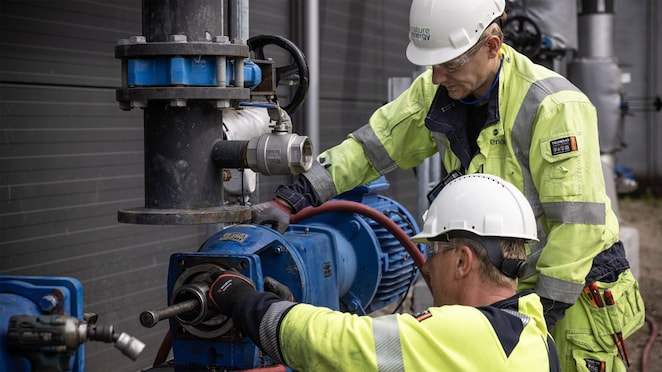 Nature Energy employees in hard hats and overalls working on pipes at the biogas plant in Midfityn, Denmark