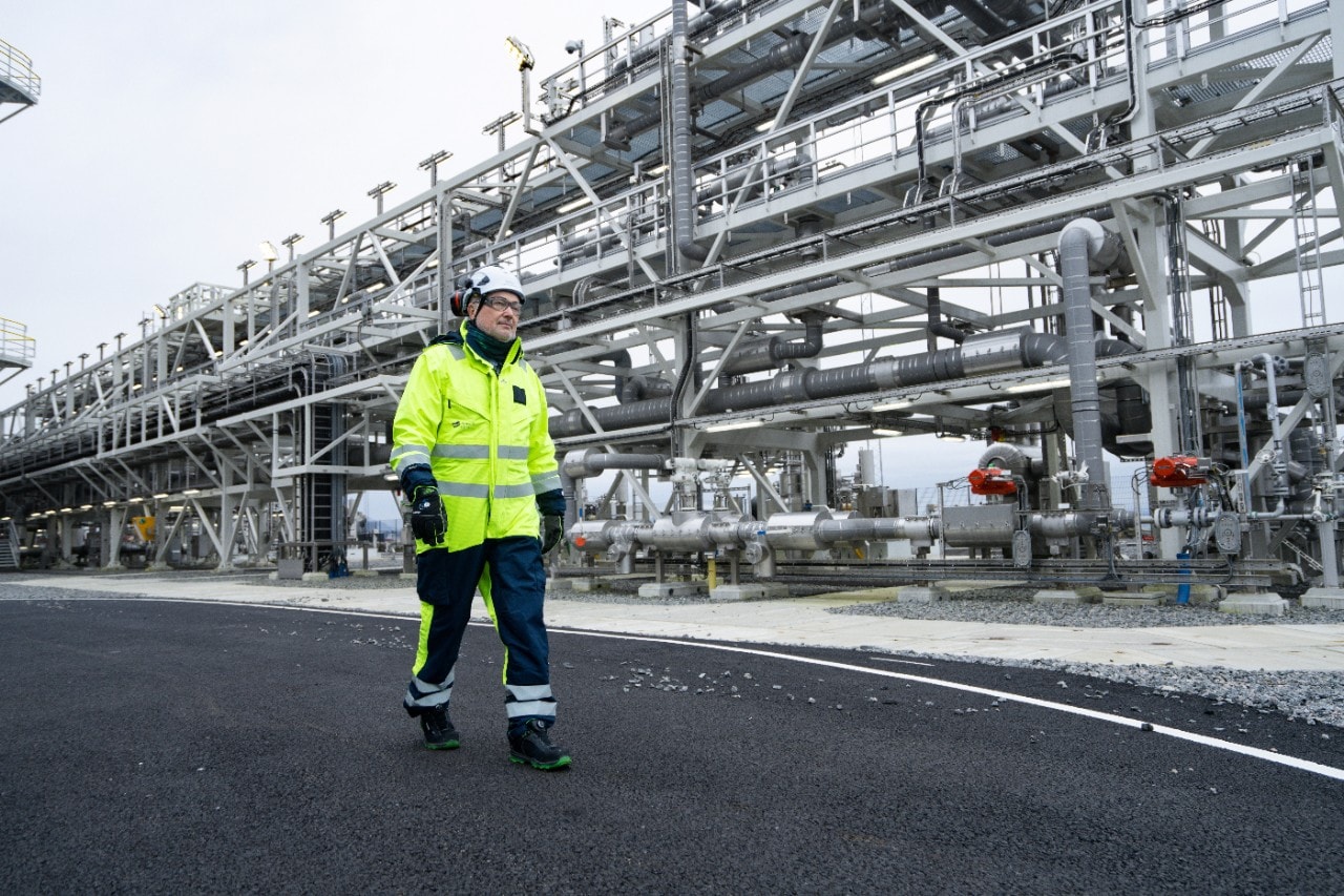 Aksel Plener, Operations Manager at Northen Lights, walks alongside the pipes that carry the CO₂ from the storage tanks to the subsea pipeline.