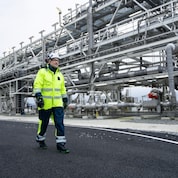 Aksel Plener, Operations Manager at Northen Lights, walks alongside the pipes that carry the CO₂ from the storage tanks to the subsea pipeline.