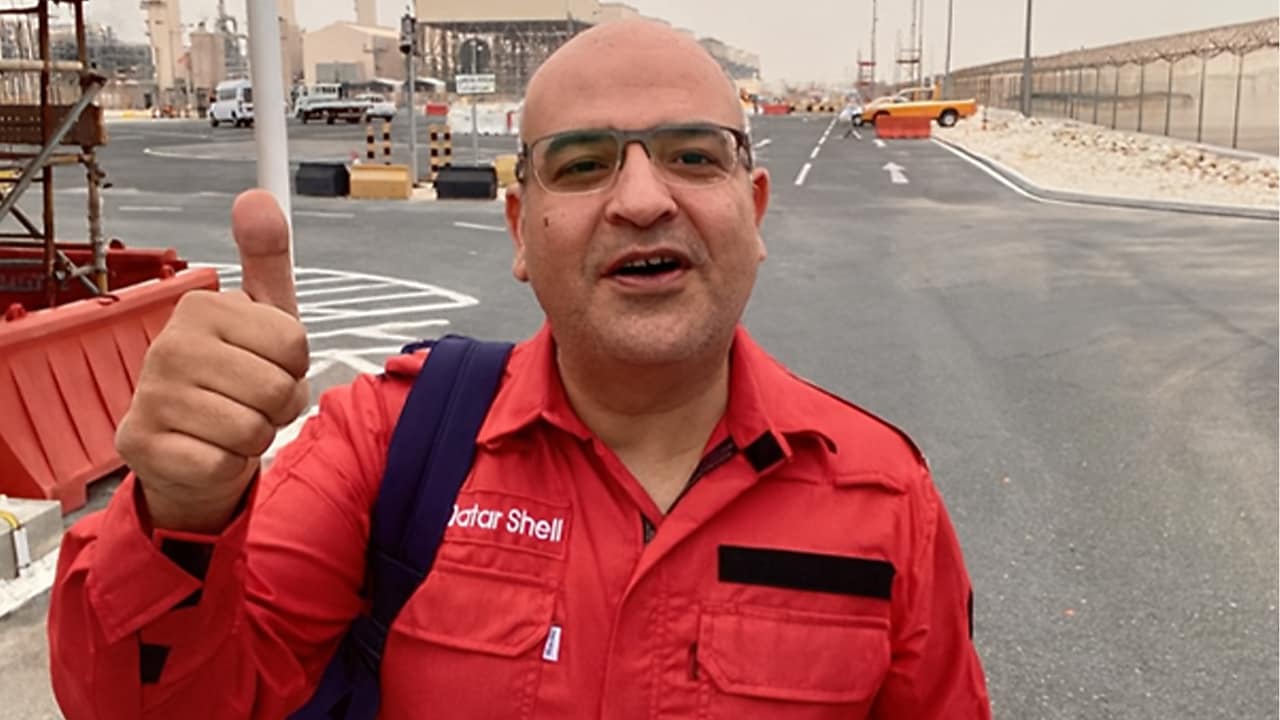 Ahmed Ali Shehata, Shell’s night-shift manager for the Pearl GTL turnaround, standing in a worksite and wearing a red overall.
