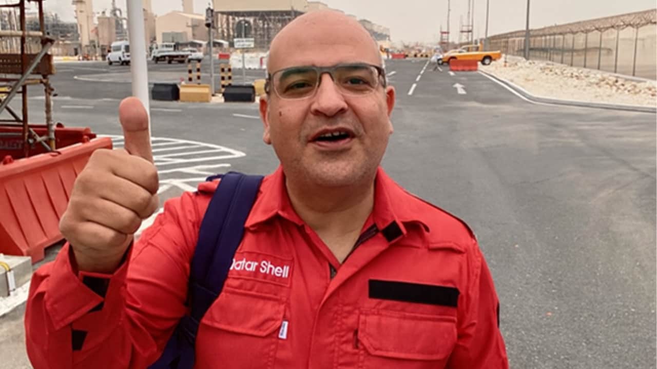 Ahmed Ali Shehata, Shell’s night-shift manager for the Pearl GTL turnaround, standing in a worksite and wearing a red overall.