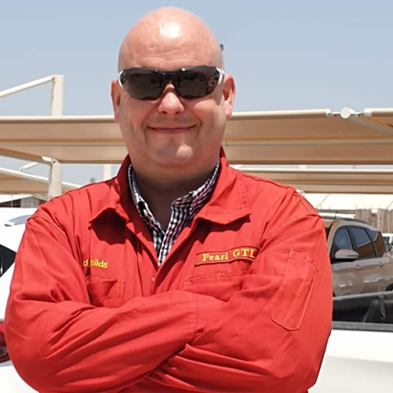 Eddie Childs, Turnaround Manager at Pearl GTL – the biggest GTL plant in the world – wearing a red overall and black sunglasses.