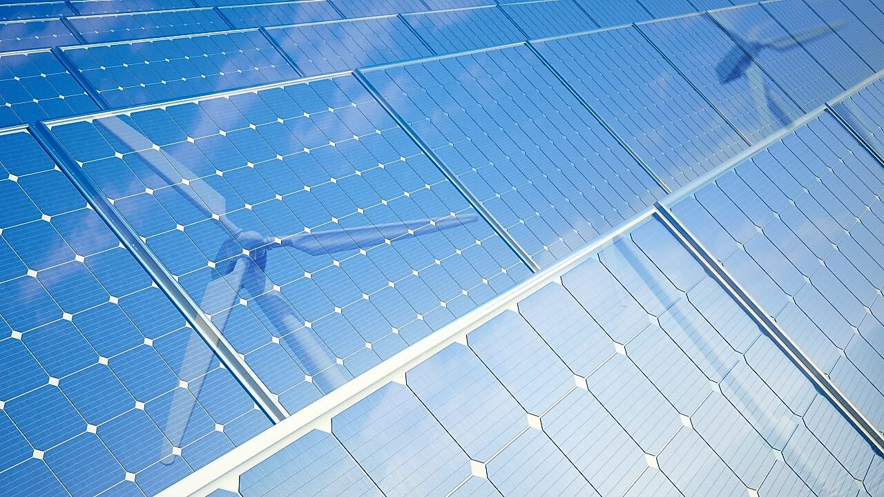Wind turbine reflecting off solar panels