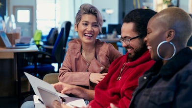 Laughing creative business people working in office