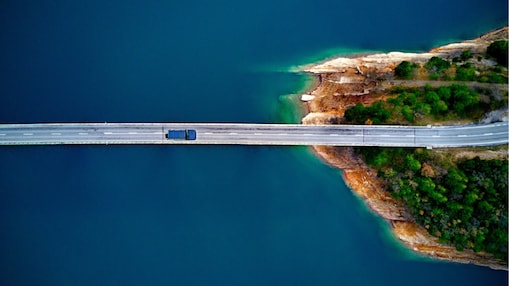 a transport truck driving on a road over water